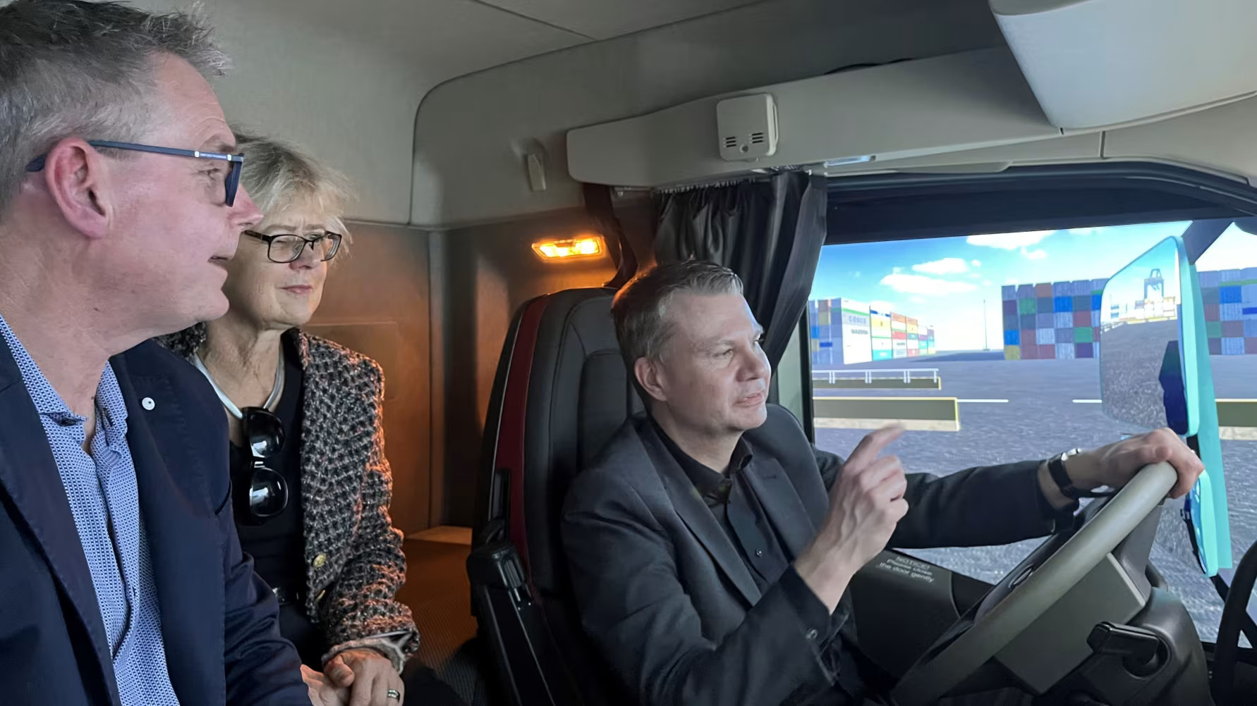     Kommunstyrelsens ordförande Ulf Olsson vid ratten. Niclas Häggblad, Söderkulla Tung Trafik instruerar med Lena Larsson, Volvo Group Truck Technology, som passagerare. Foto: Borås Stad. 